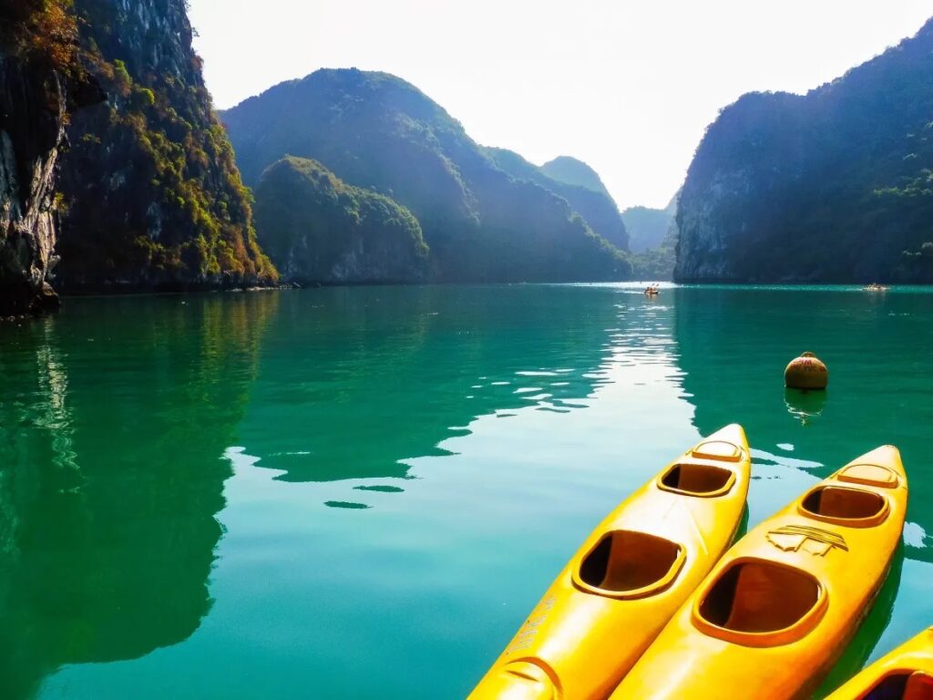 Lan Ha Bay kayaking yellow kayaks emerald green water limestone karst