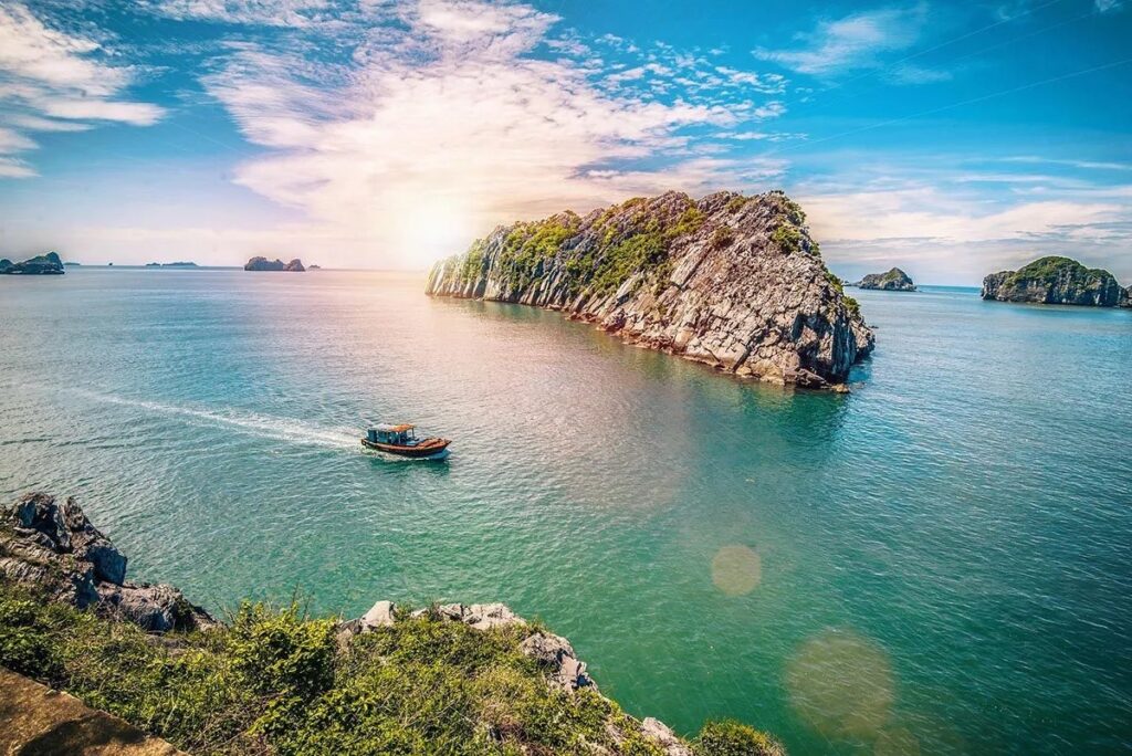 Lan Ha Bay limestone karst island boat sunset golden light