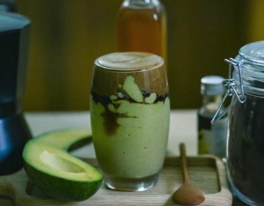 Avocado coffee blended with condensed milk and topped with black coffee