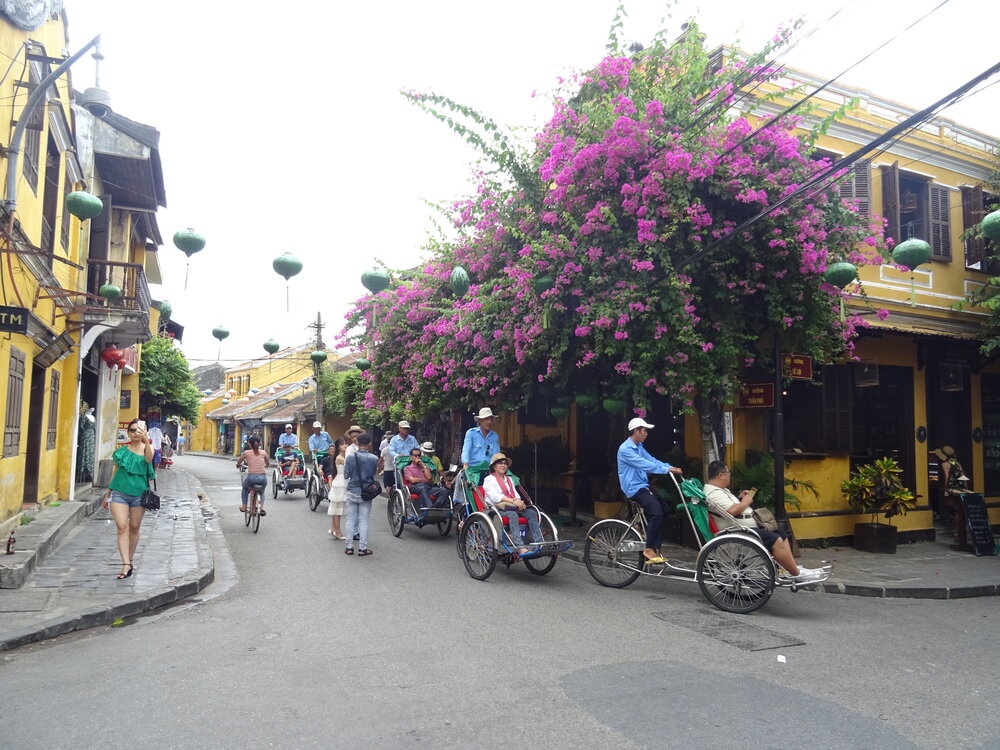 Cyclos and bicycles along a street in Hoi An ancient town
